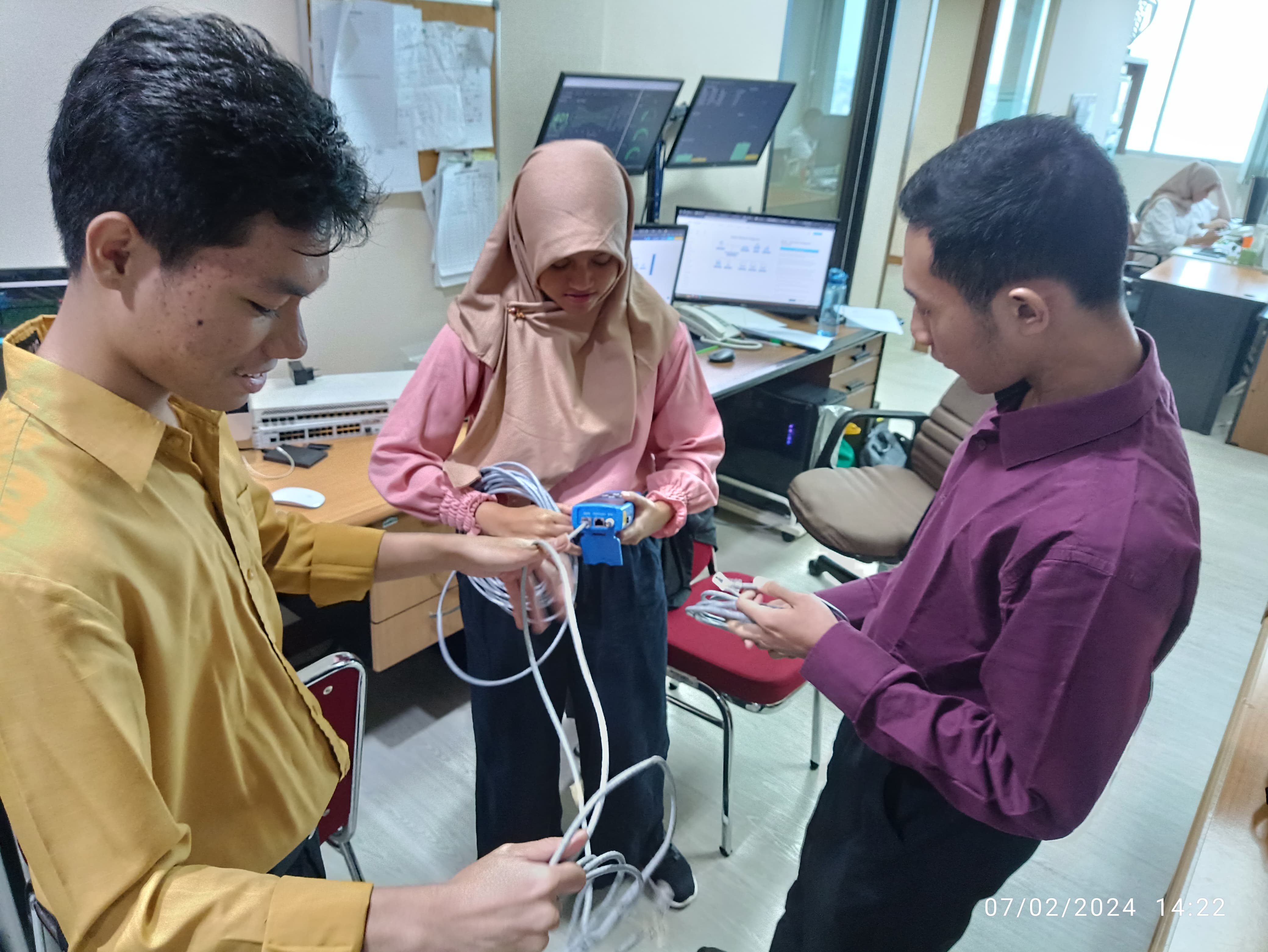 Me, Aira and Abim holding the ethernet cables to connect our three PCs together through a switch.